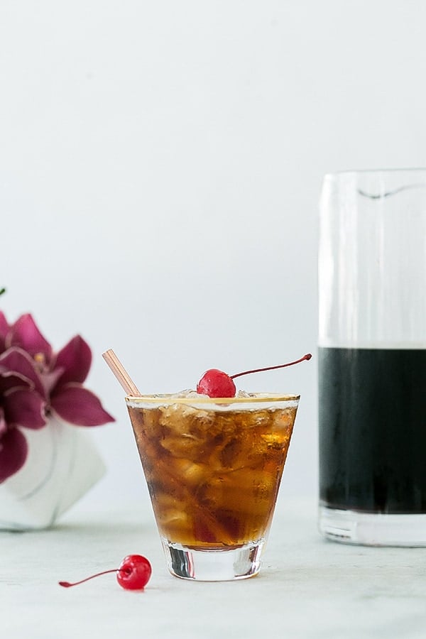 Coffee tonic recipe with a red cherry on top.