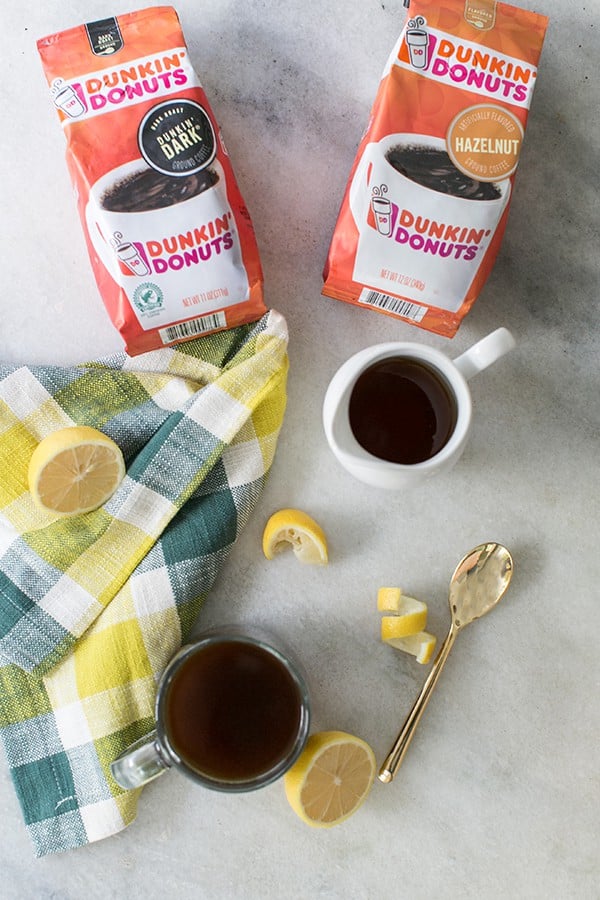 top down shot of mugs of hazelnut coffee and packs of dunkin donuts ground coffee 