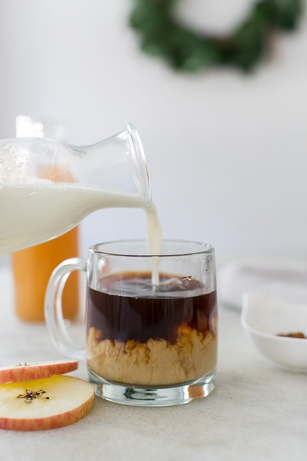 Pouring cream into black coffee.