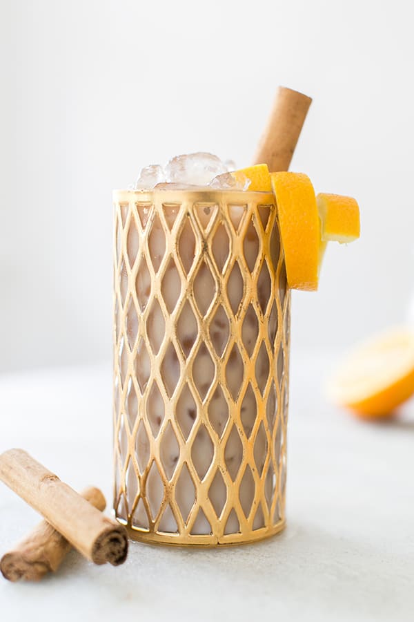 Cold brew coffee recipe in a cold class with an orange rind and cinnamon stick 