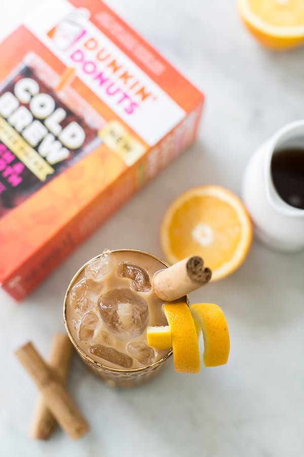 Dunkin' Donuts Cold Brew Coffee brewed in a glass with a cinnamon stick and orange rind. 