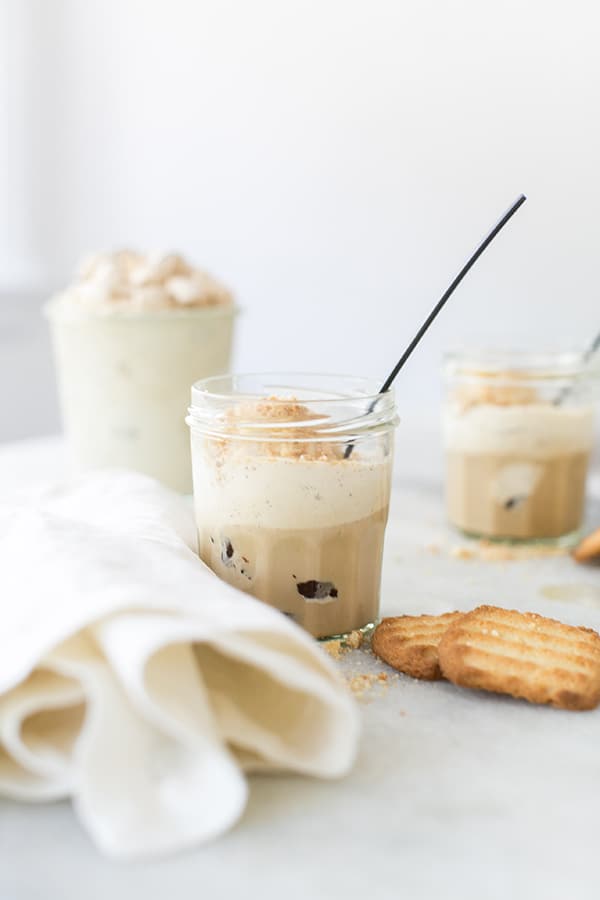 An Easy Tiramisu Coffee Dessert Recipe in a glass with a black spoon on a table.