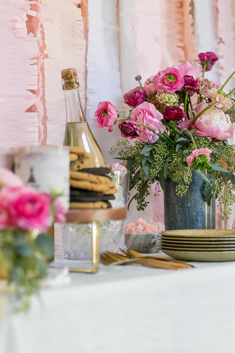 Valentine's Day bar with flowers, cookies, plates and sparkling wine.