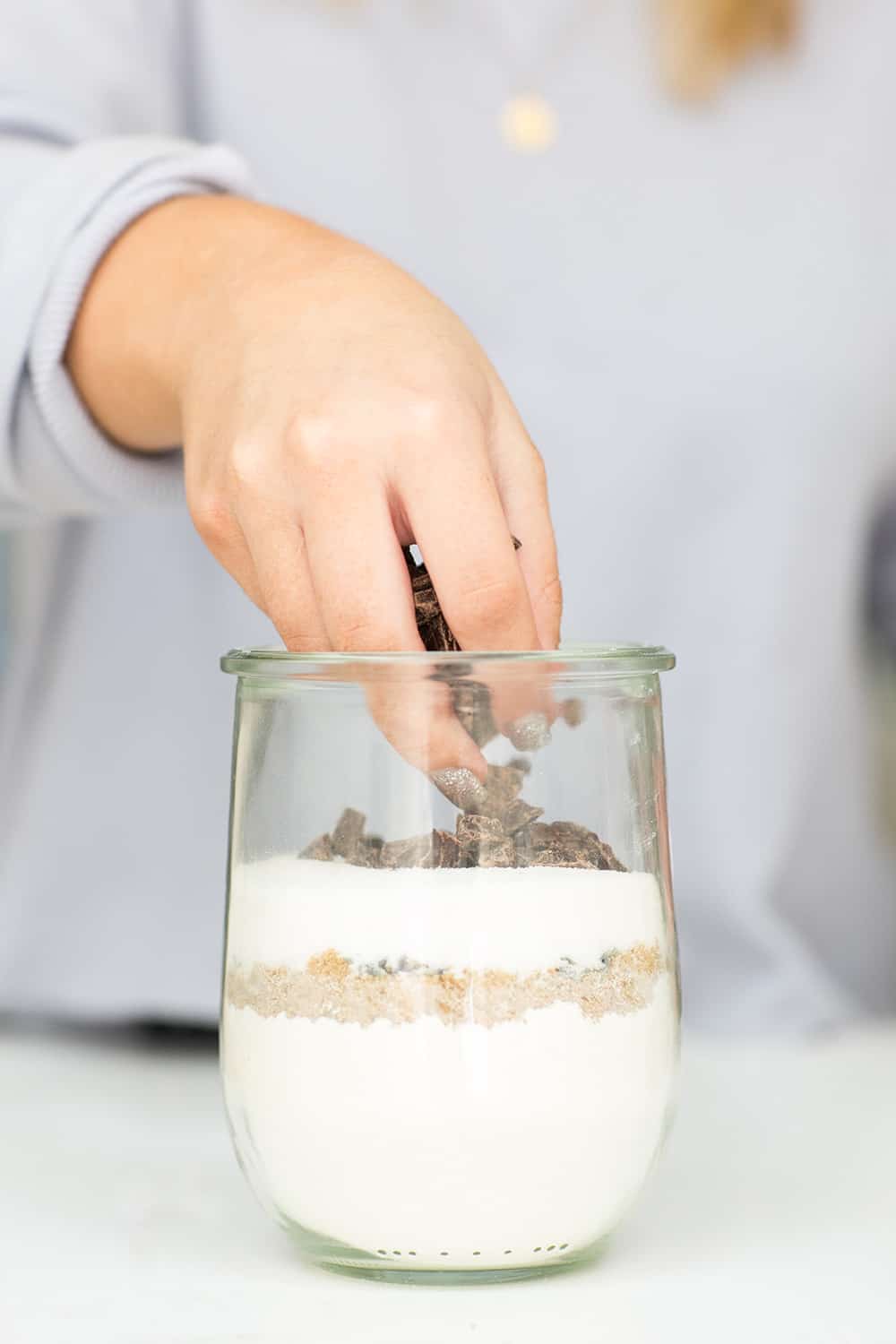 layering chocolate on top layer in jar, creating cookie mix in a jar