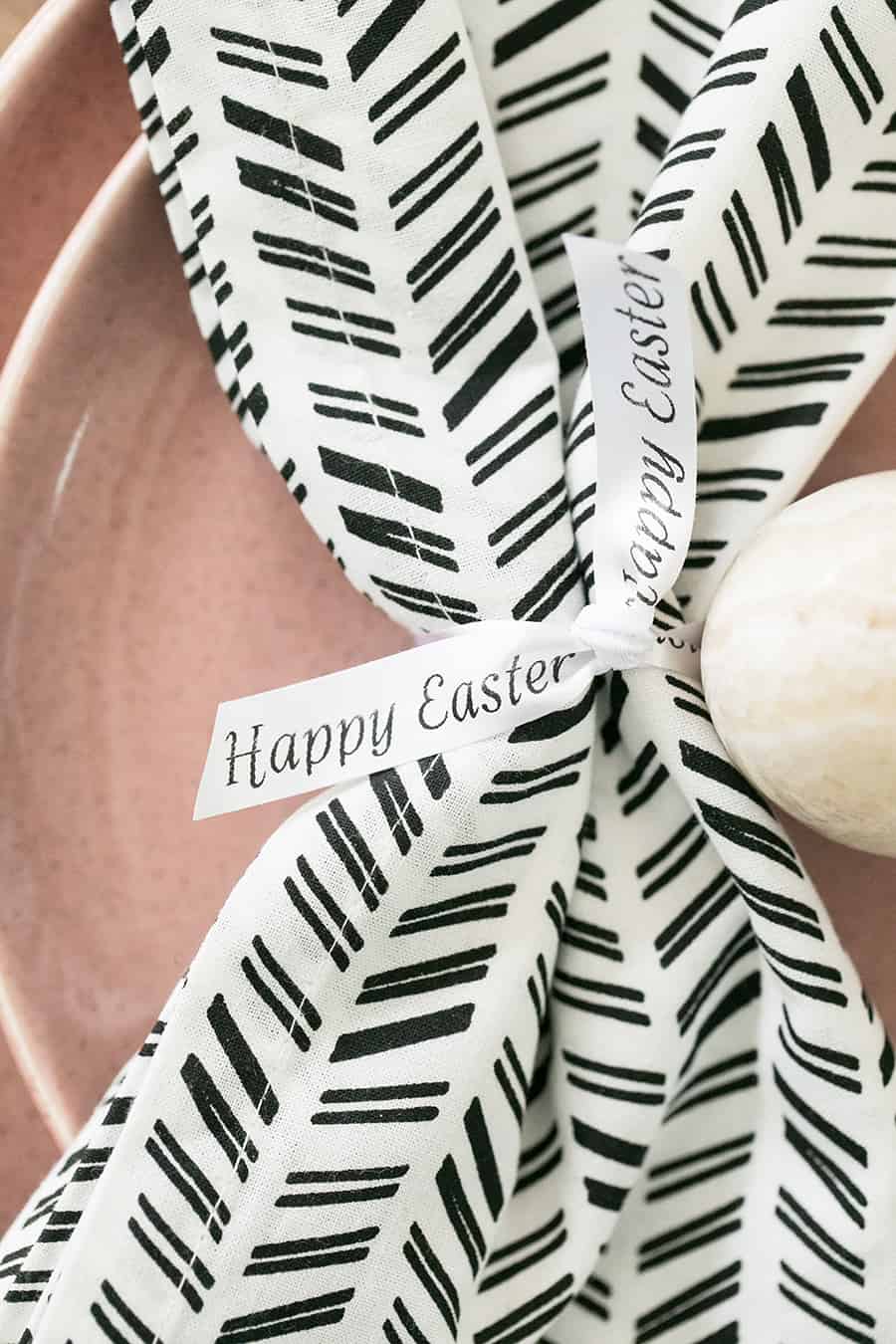 Black and white napkin with custom "happy Easter" ribbon tied around the napkin.