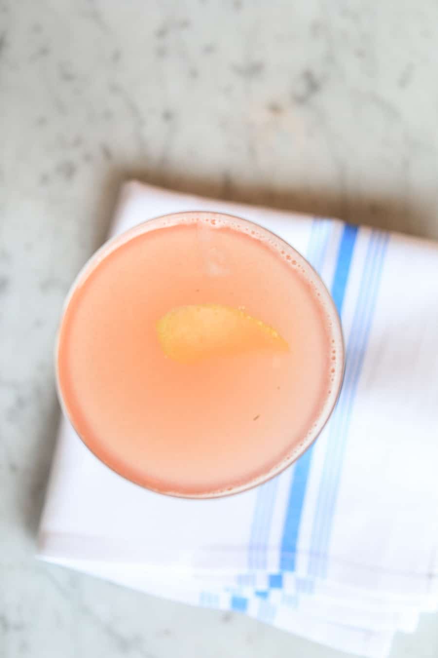 Pink cocktail on white and blue napkin