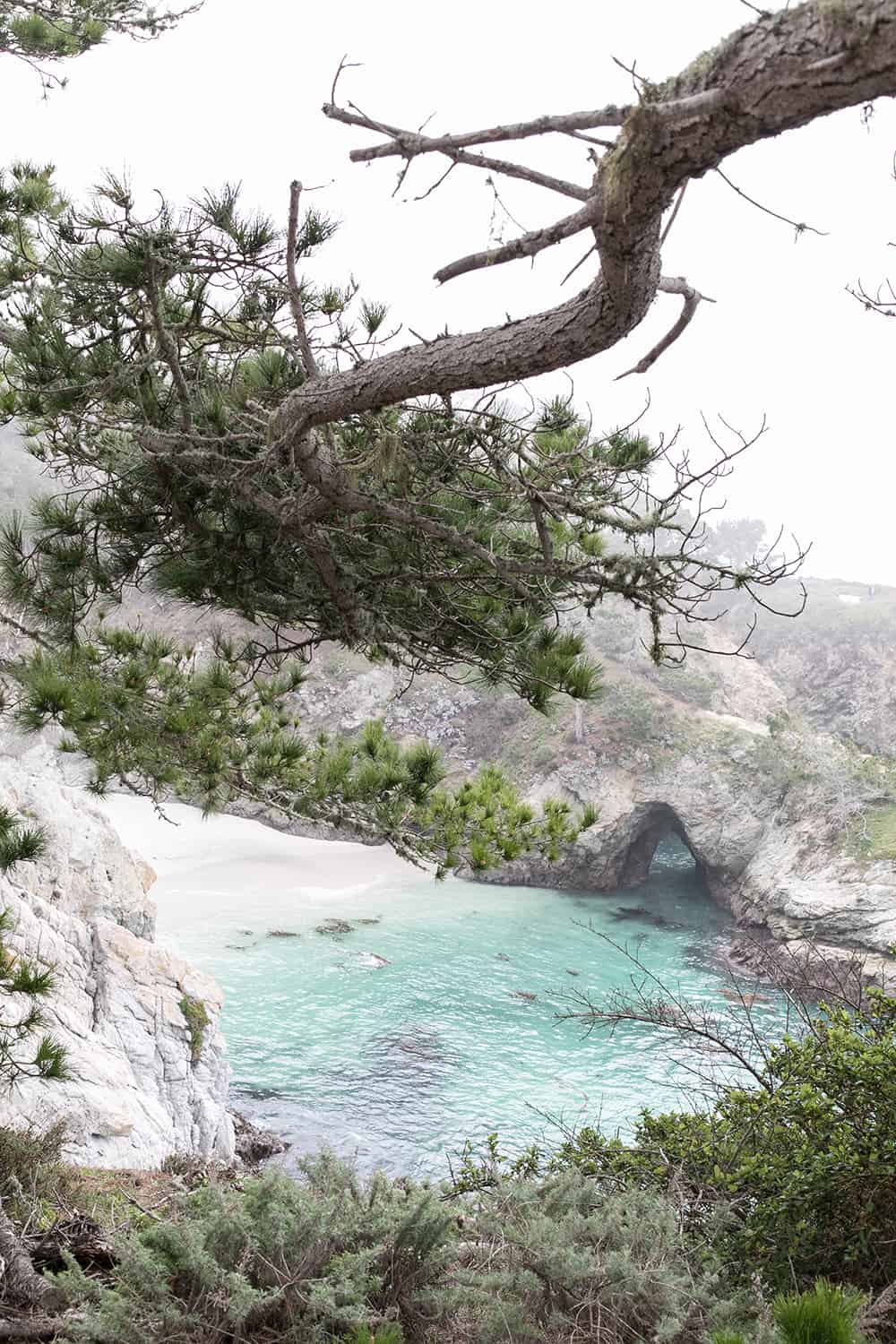 Blue beach with white sand and cliffs