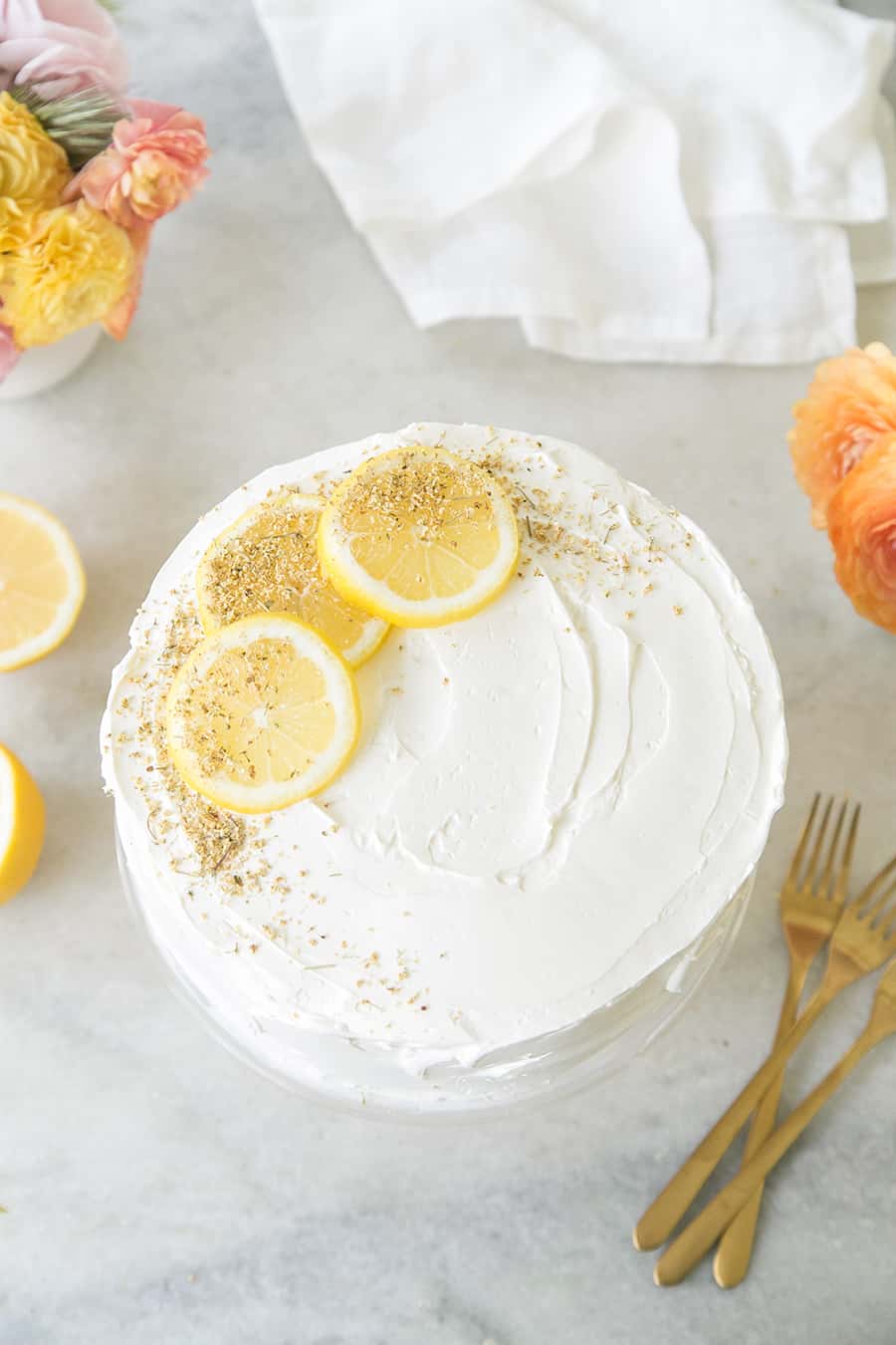 A lemon elderflower cake decorated with slices of lemon