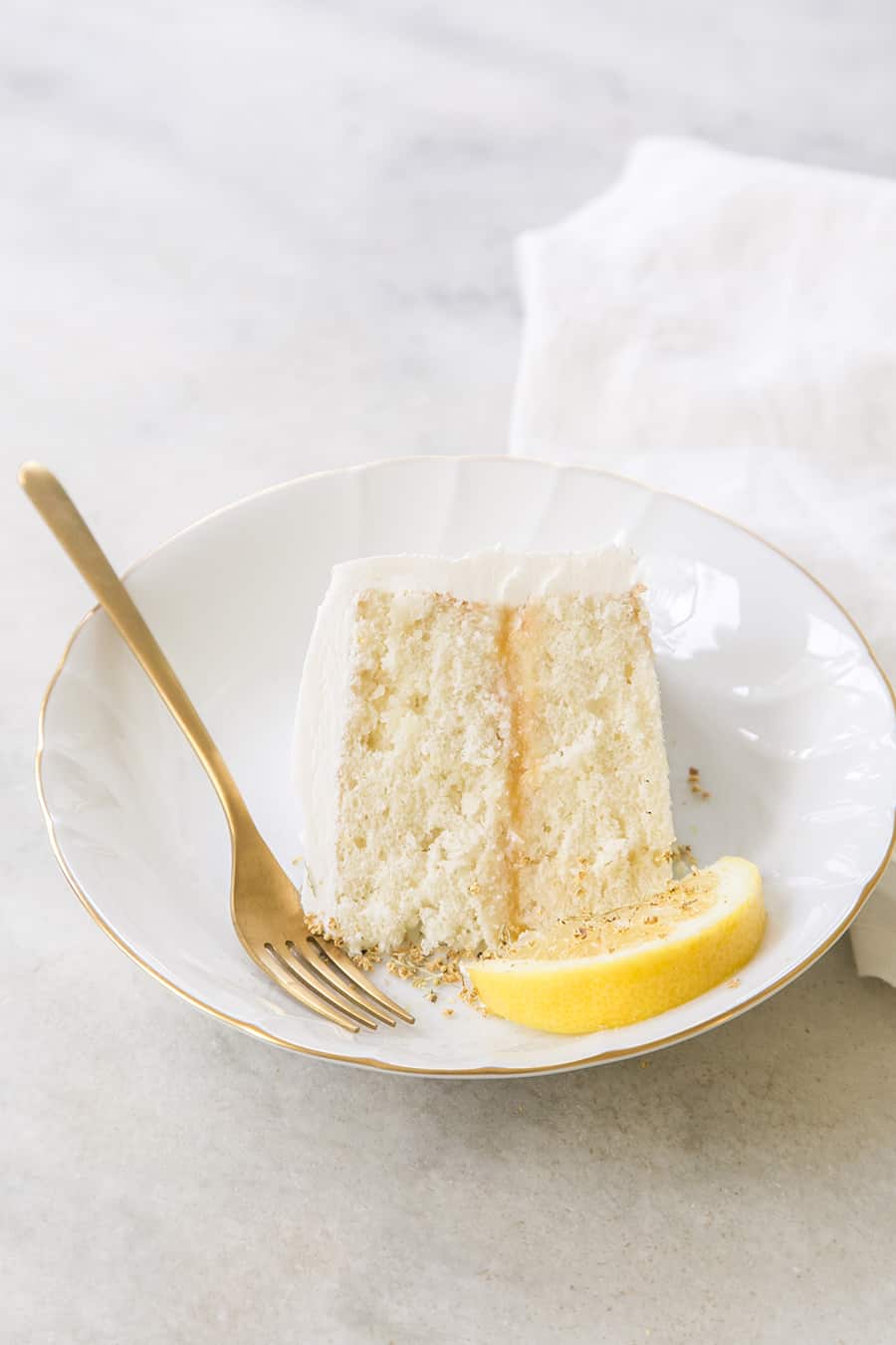 A slice of lemon elderflower cake on a white plate