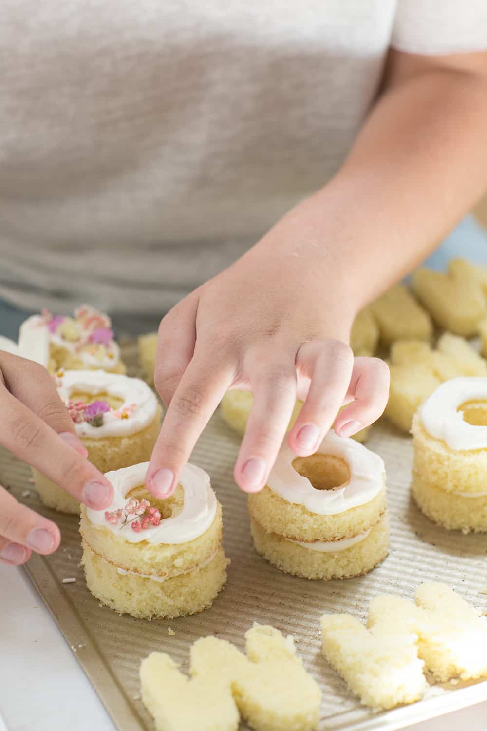 pressing flowers onto mini cakes