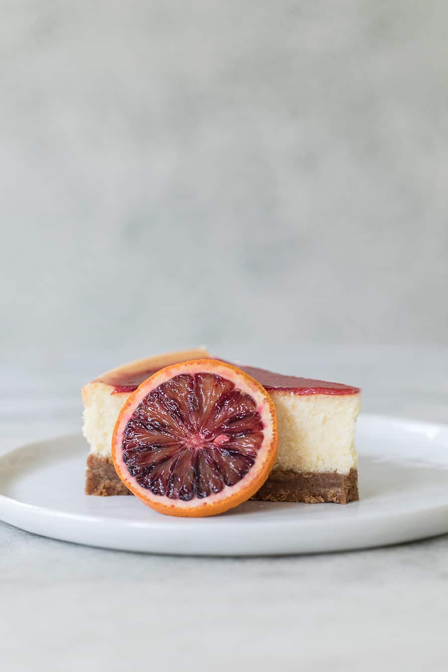 Slice of blood orange cheesecake with a slice of blood orange.