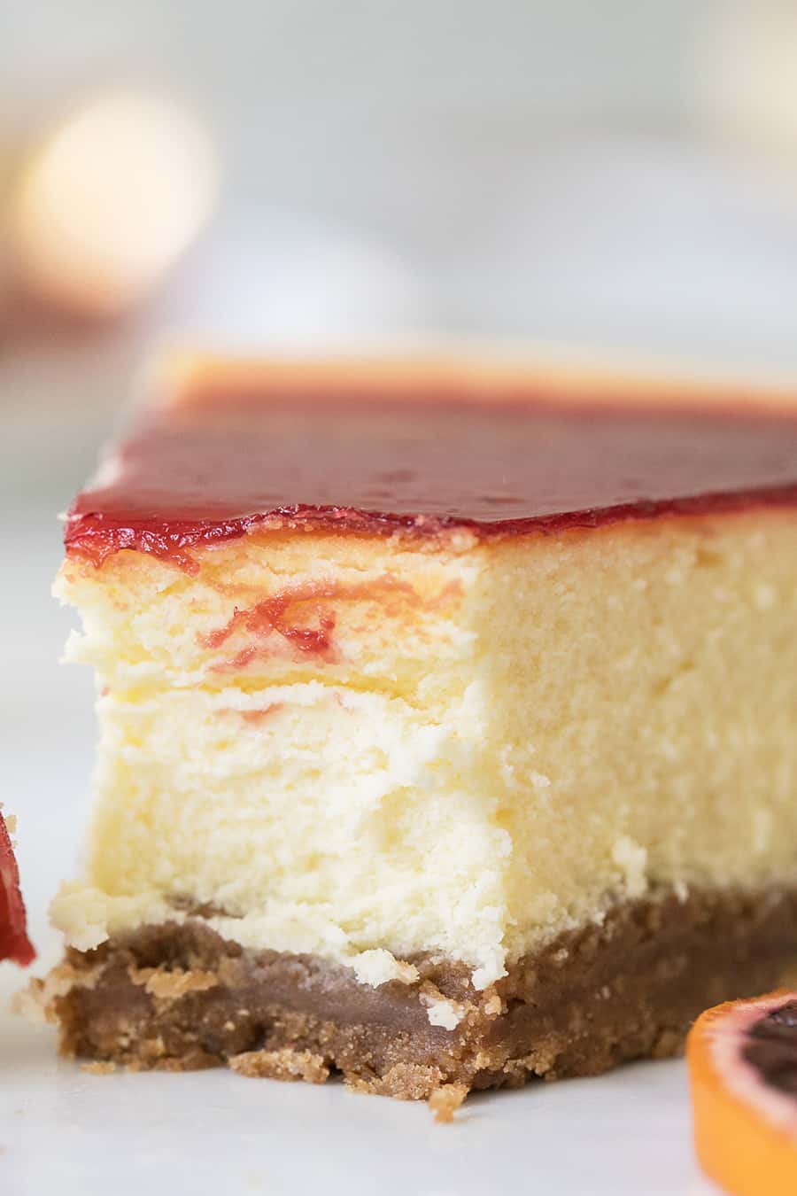 Slice of cheesecake with blood orange sauce.