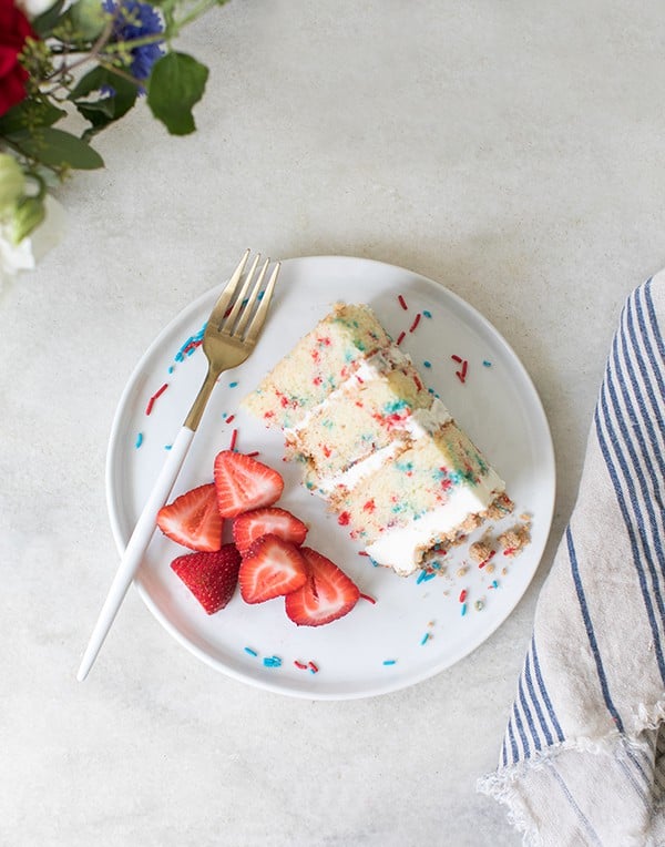 slice of funfetti dessert on a plate with strawberries