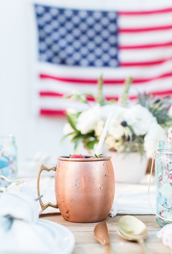 Blueberry Moscow Mule in a copper mug on a 4th of July table setting.