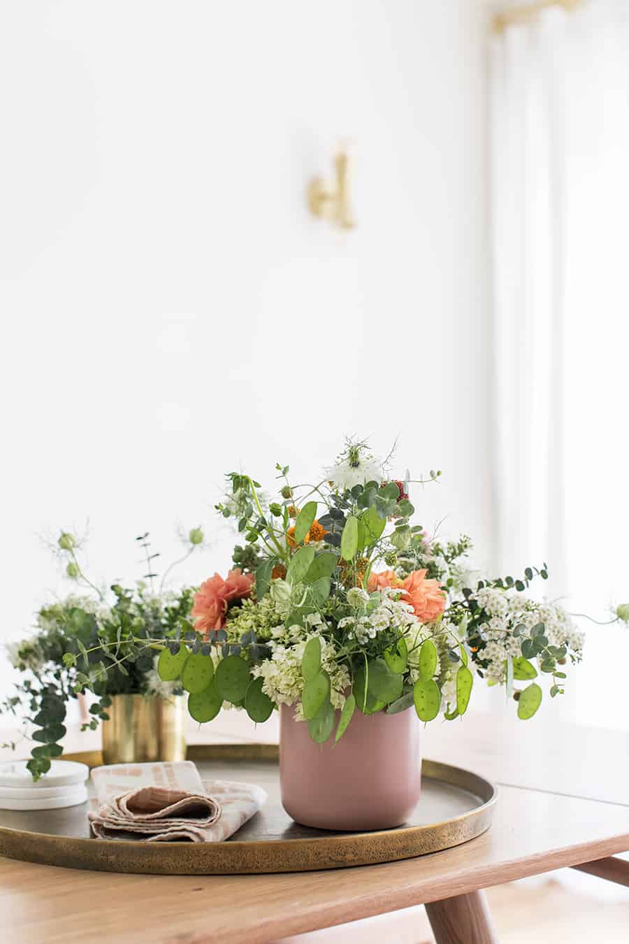 Flowers in a pink vase with brass tray