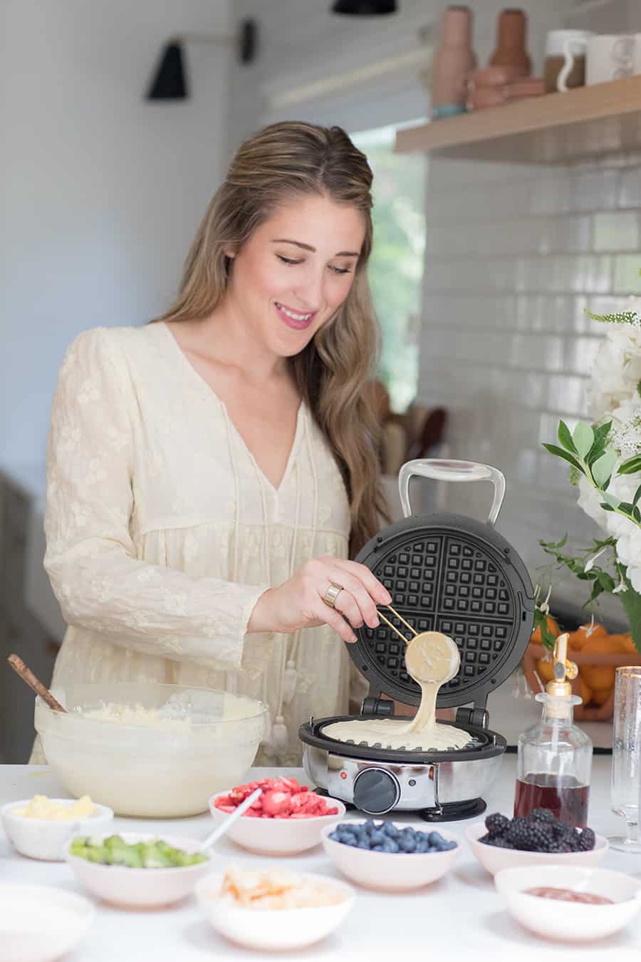 Eden Passante making homemade waffles in a round waffle maker. 