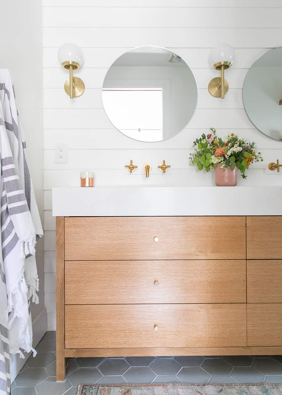 Custom bathroom vanity with three drawers, round mirror, gold hardware, gold scones. - small bathroom remodel