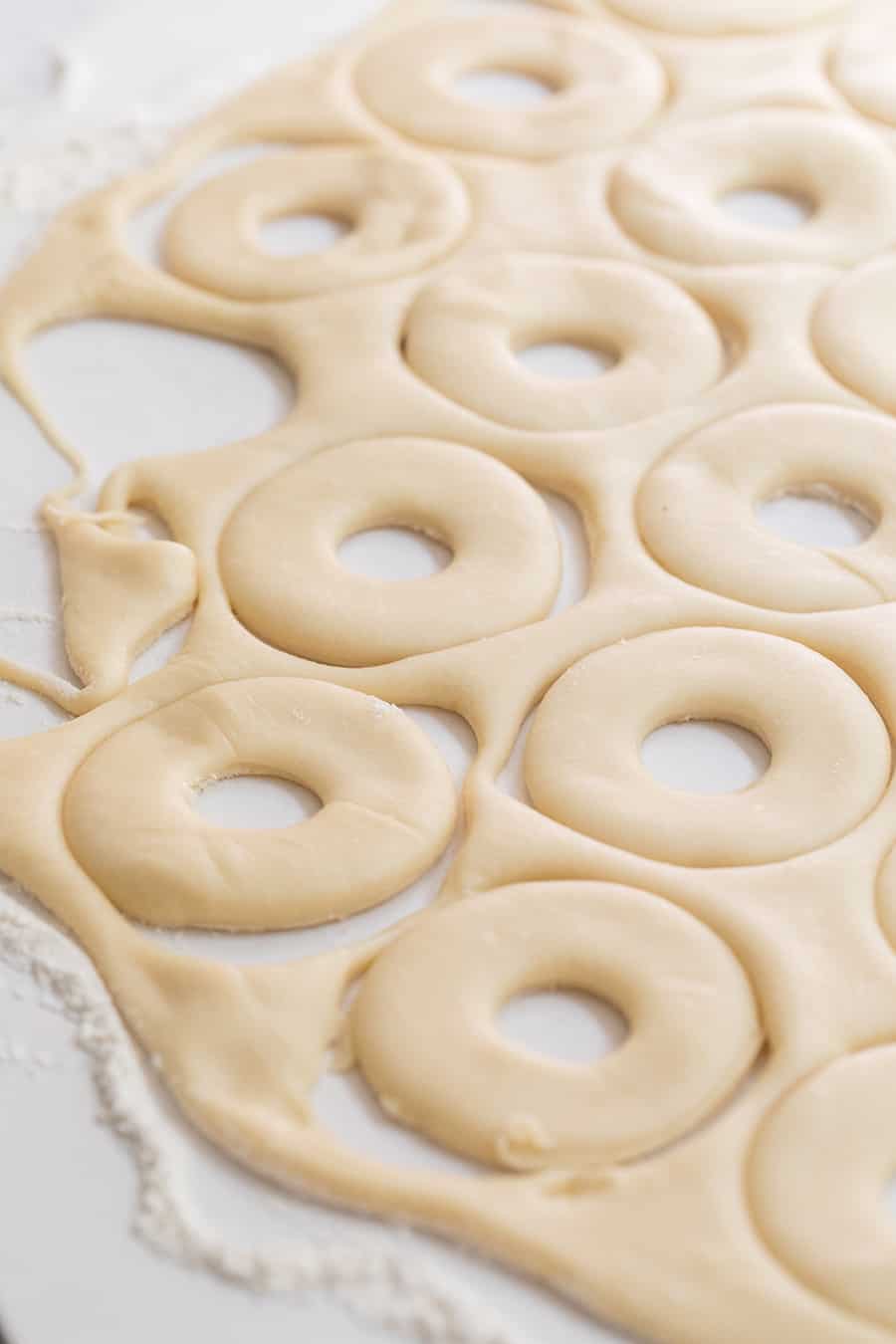 side shot of dough with donut shapes cut out