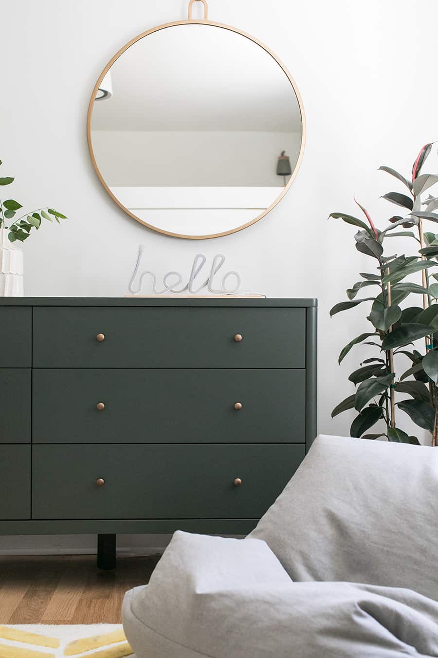 Olive green dresser with hello sign and a gold mirror