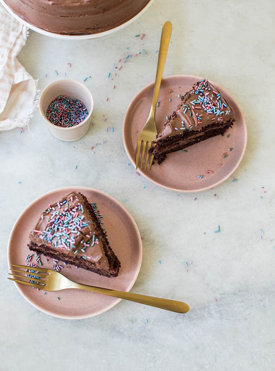 top down shot of slices of chocolate cake with sprinkles on pink plates