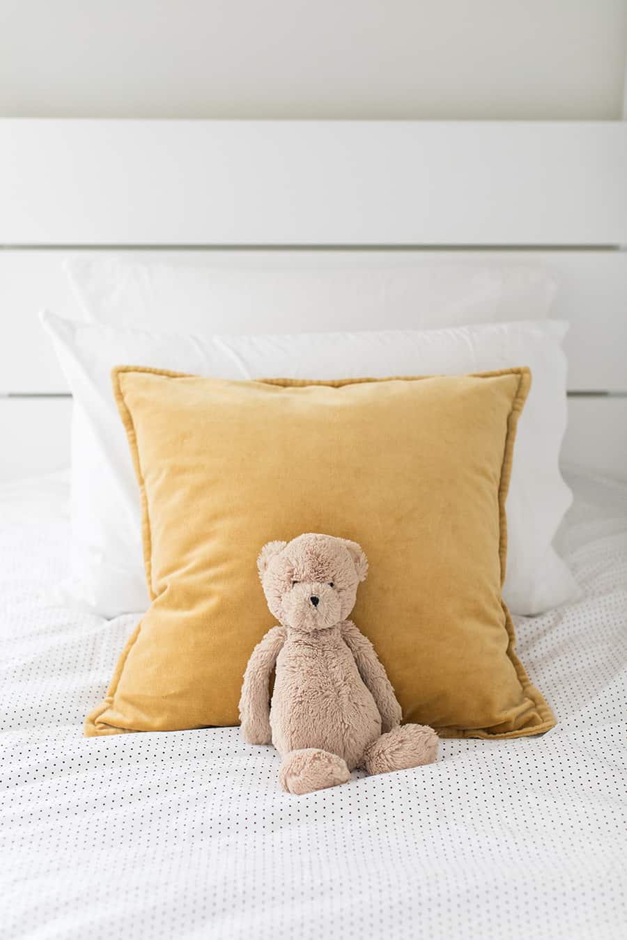 Velvet pillows with a stuffed teddy bear.