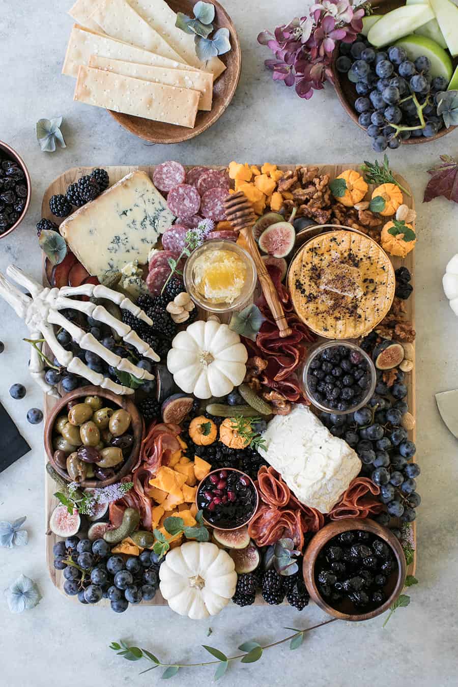 Halloween Meat and Cheese Board with pumpkins, berries, pickles, olives, cheese and meat.