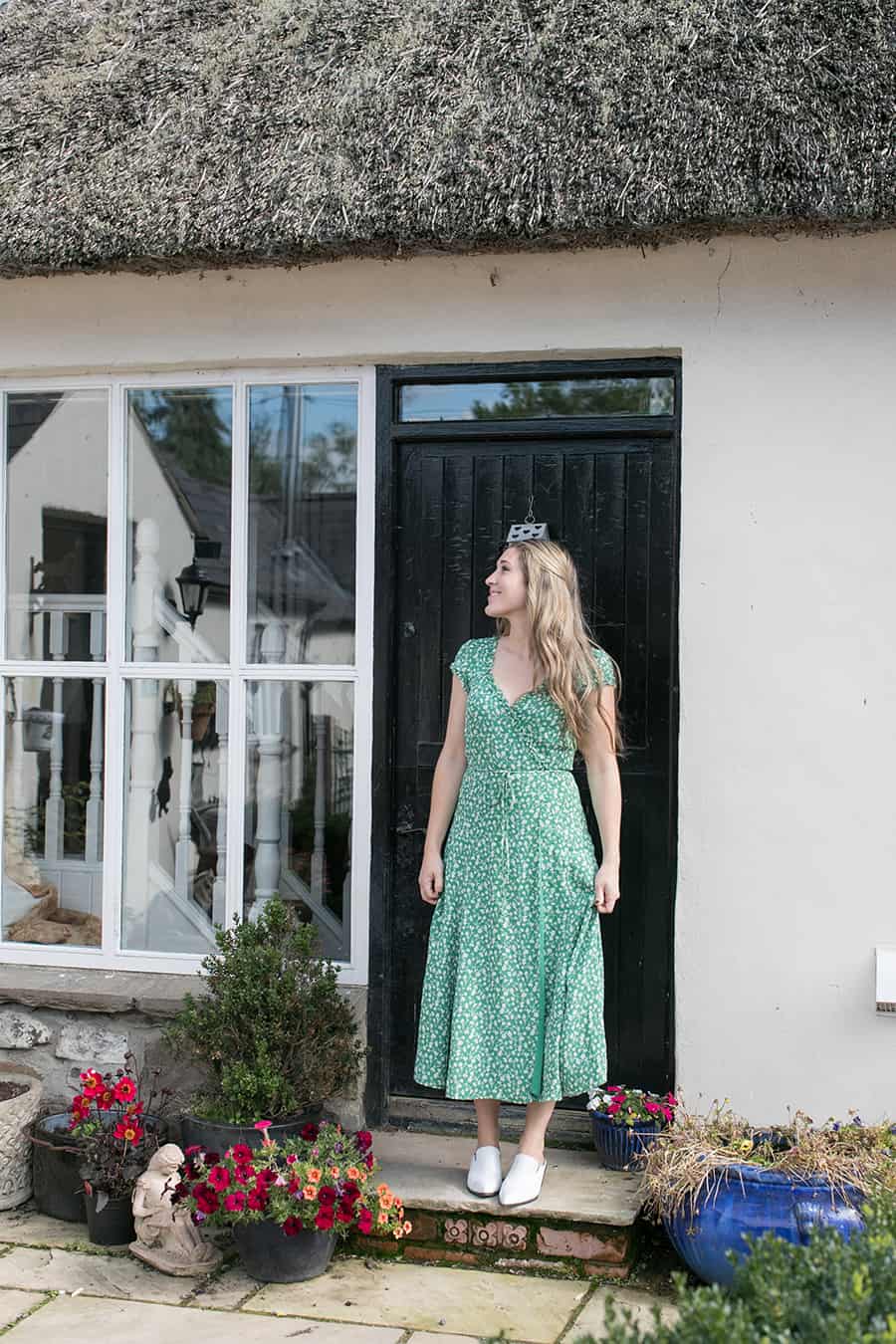 Eden Passante standing outside a cottage in Northern Ireland.