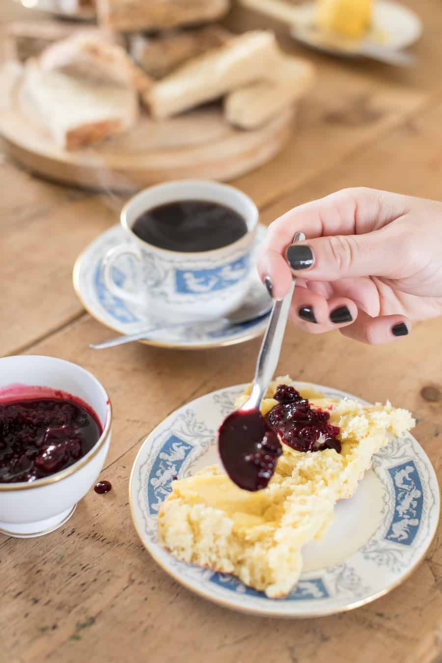 Spooning jam onto a biscuit.