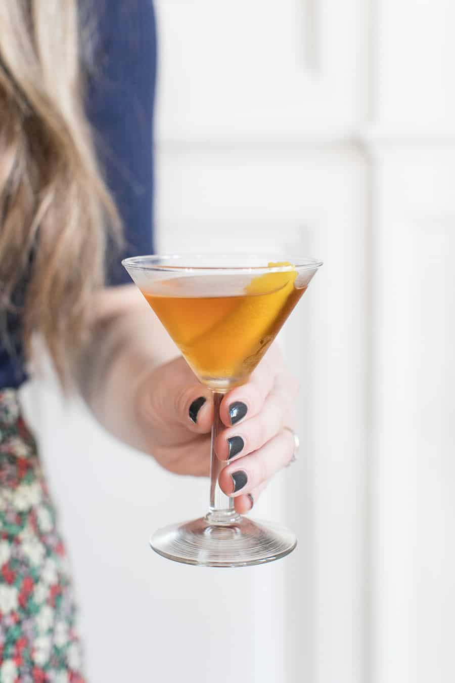 Holding a Bénédictine cocktail in a martini glass.