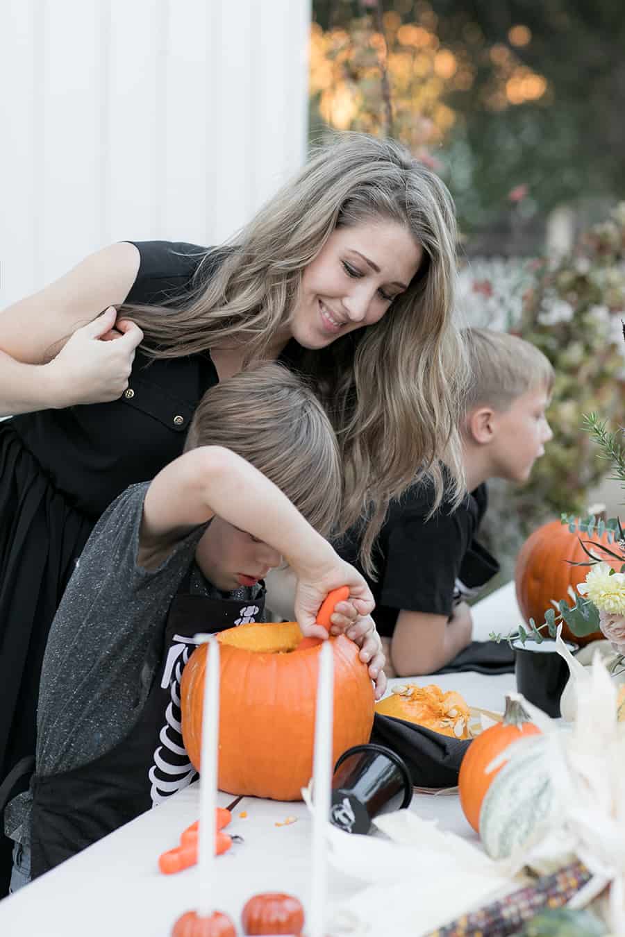 Eden Passante helping child carve a pumpkin 