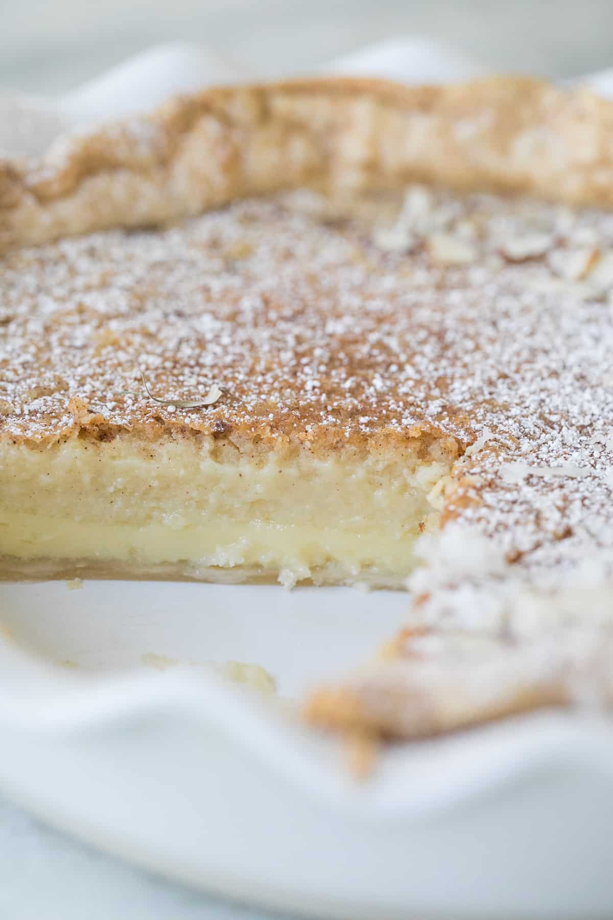 slice taken out of an egg custard pie - homemade pie crust, pie plate, why is scalded milk, ground nutmeg, pie dough, pie tastes, custard filling