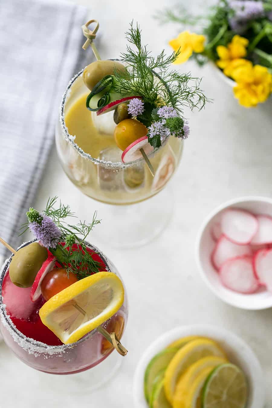 wine glass of bloody Mary mix with flowers and olives 