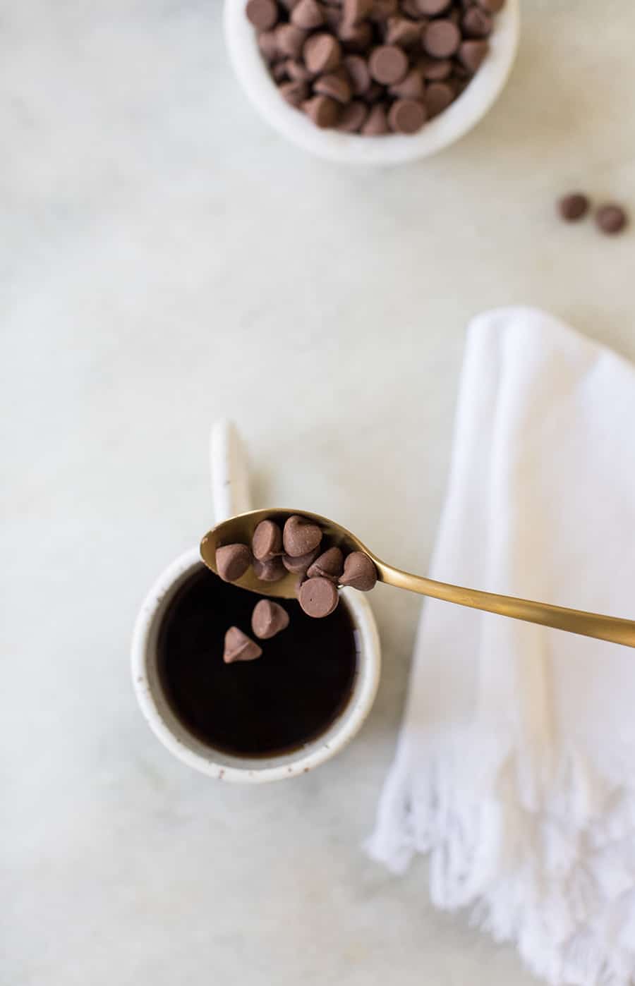 top down shot of chocolate chips falling into a mug