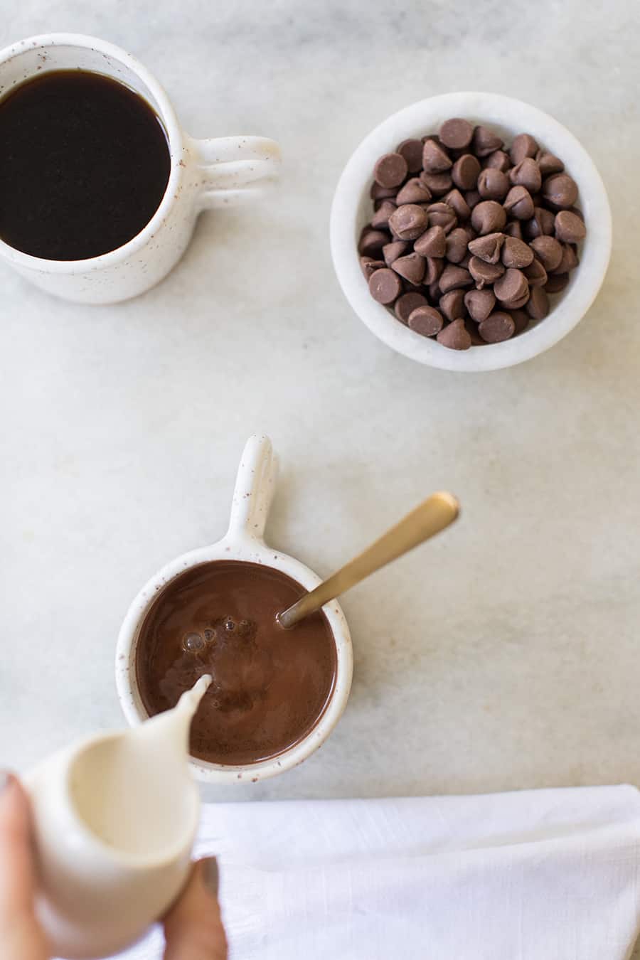 top down show of milk being poured into the caramel coffee