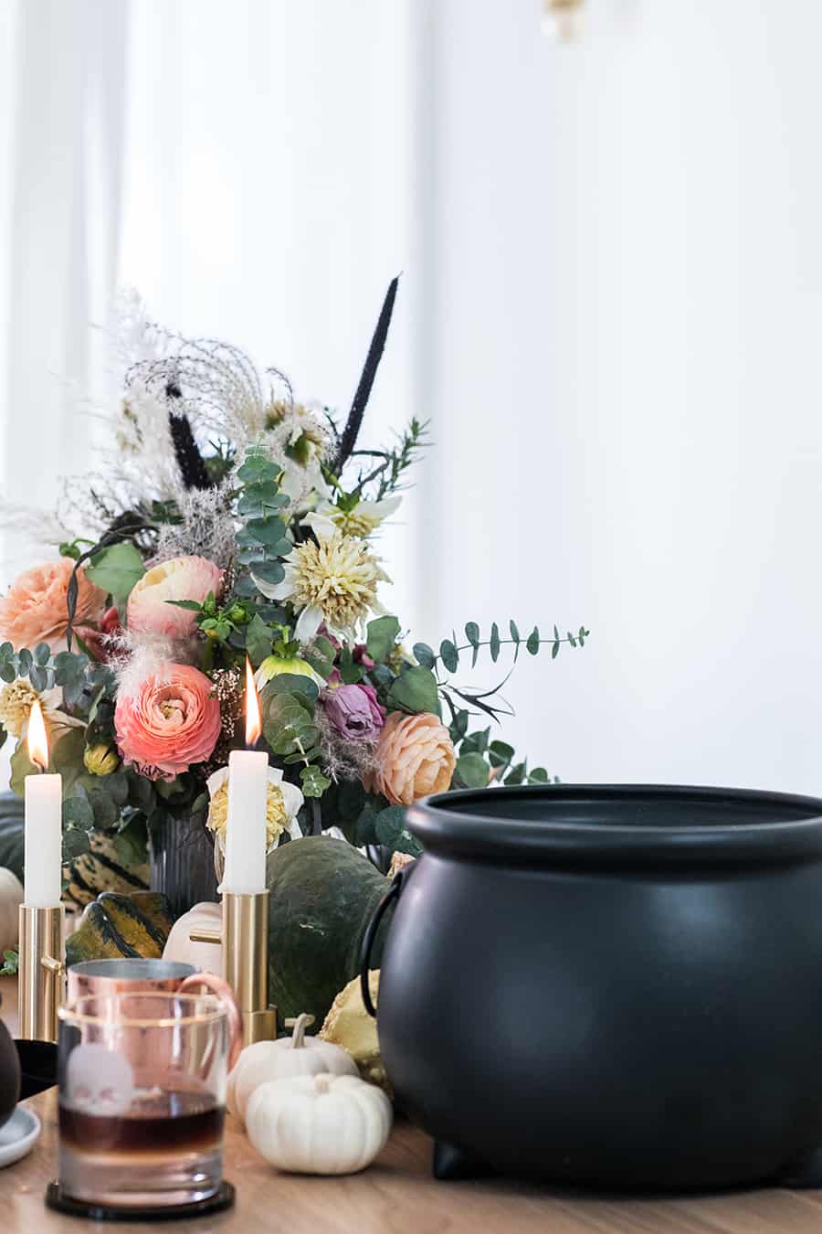 cauldron filled with curried butternut squash soup on a Halloween dinner table.