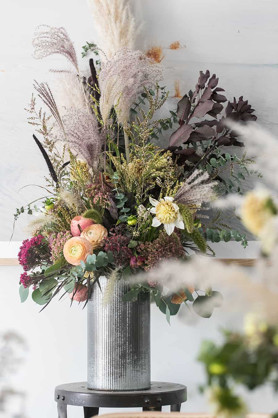 Halloween Dinner Ideas Decorations with flowers in a tall metal vase.