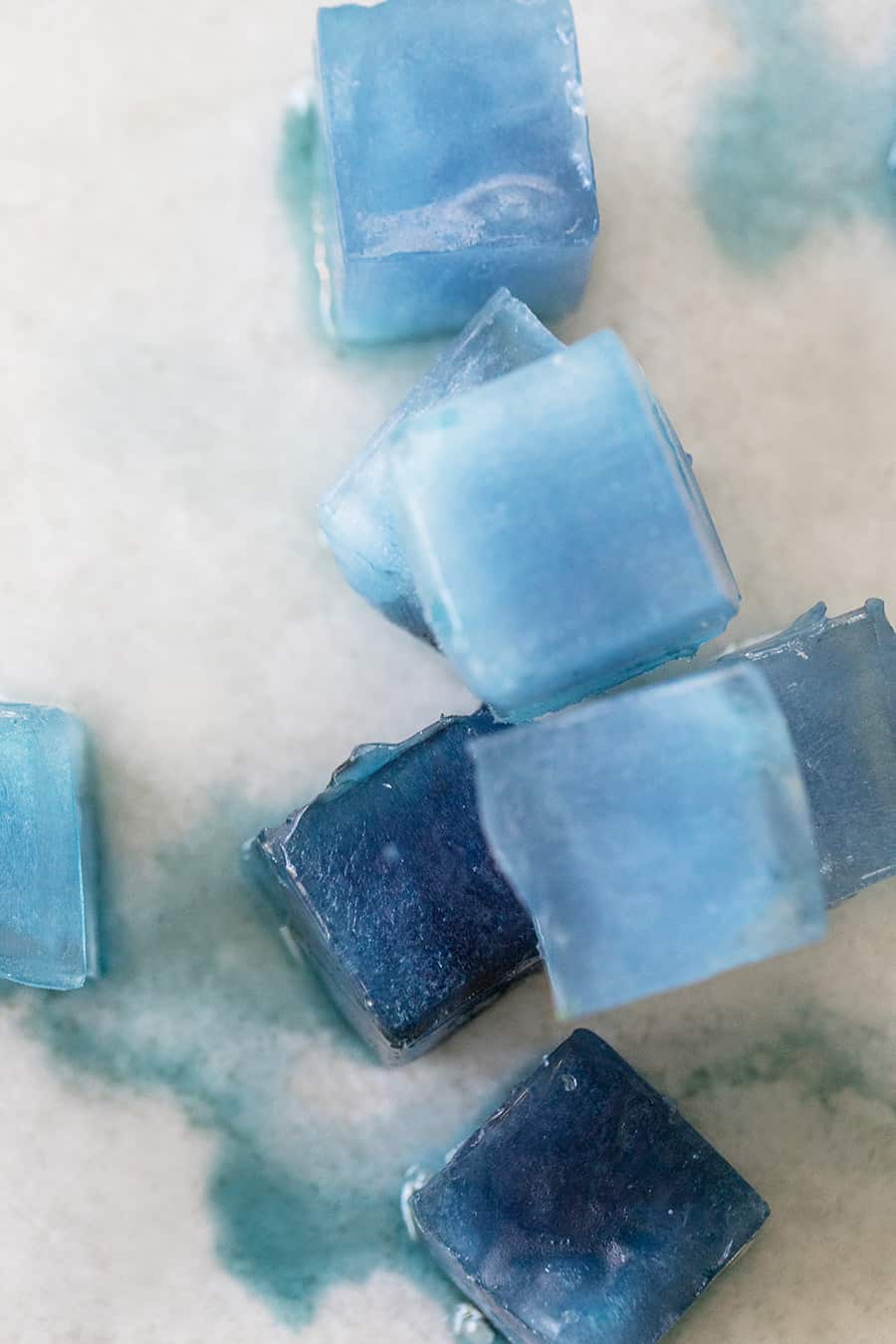 Natural blue ice cubes on a marble table. 
