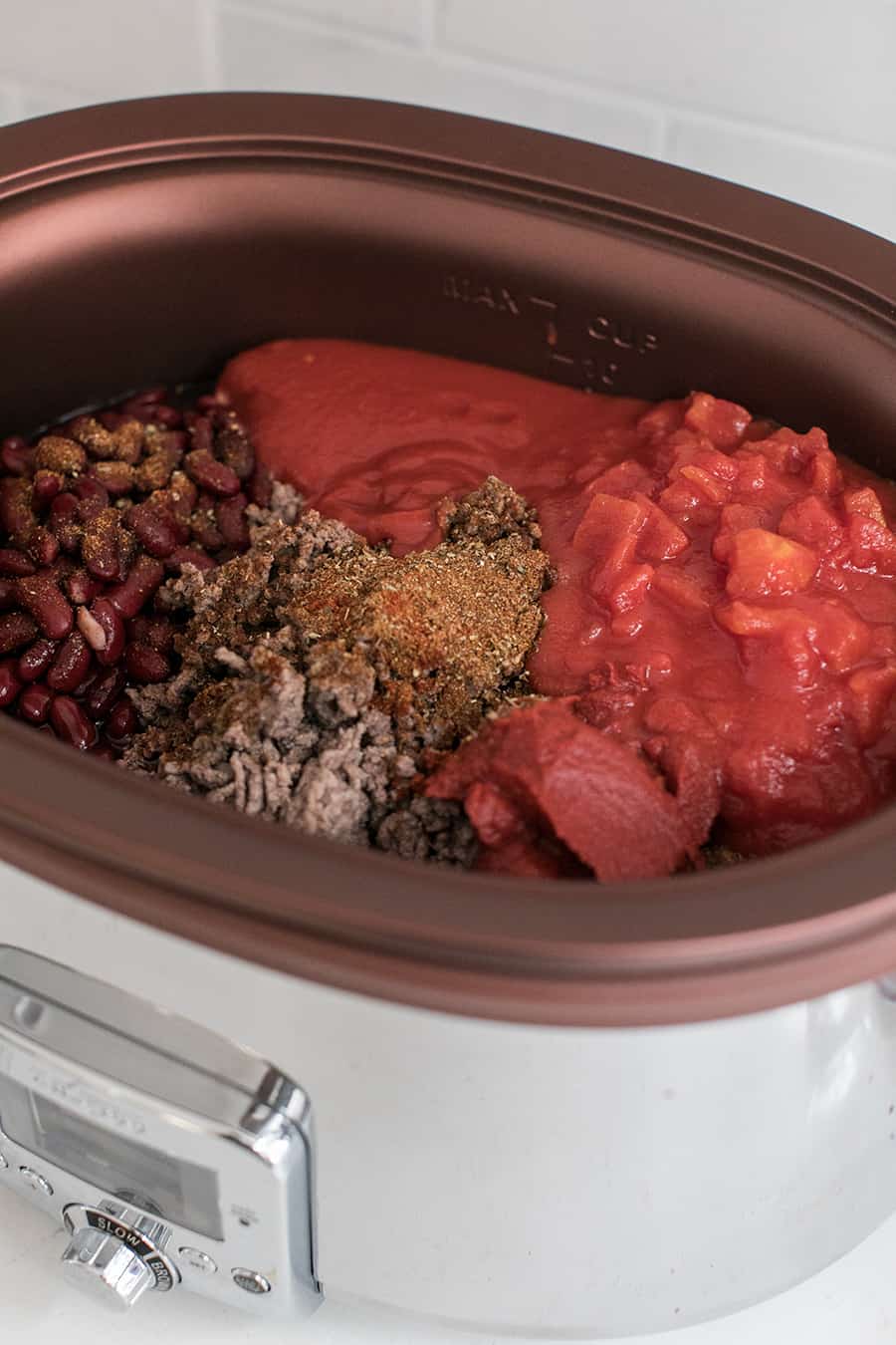 ingredients for the best slow cooker chili recipe in a pot - tomato sauce