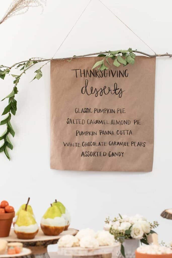 DIY dessert table sign made with wood and a brown paper and twigs.