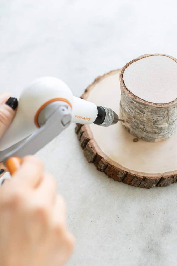 Putting a hole into a cake stand to make a dessert table.