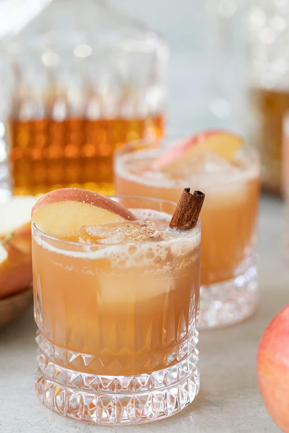 Apple cider cocktail with bourbon, apple slice and cinnamon. 