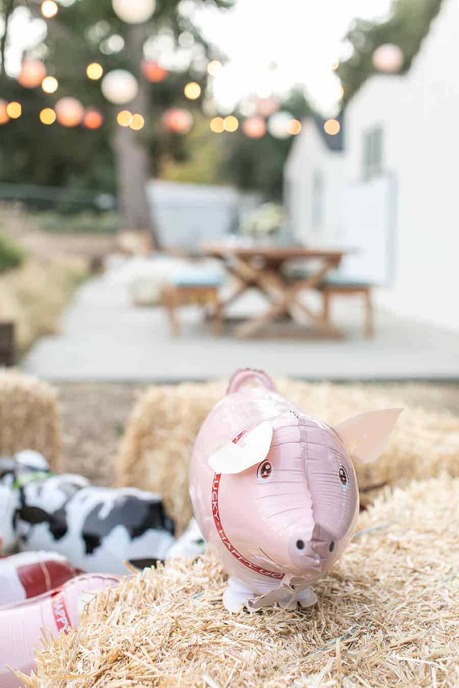 Pig balloon on hay bale at a barnyard birthday party 