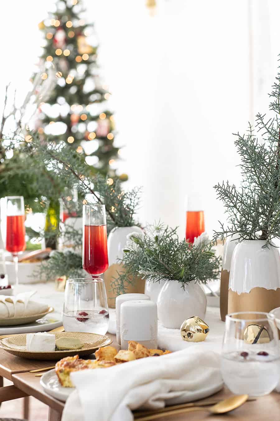 Christmas brunch table setting with white and gold and cranberry mimosas 