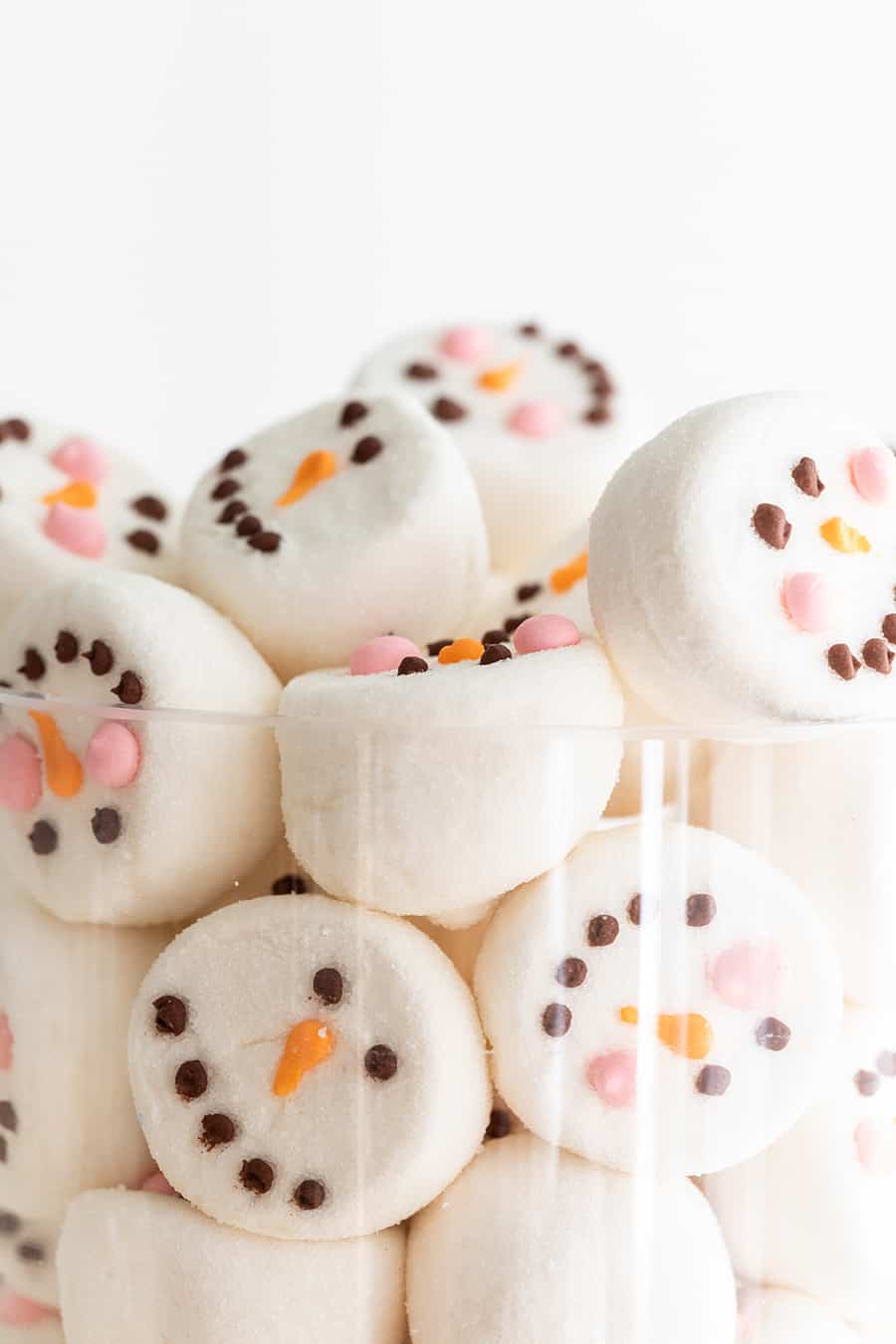 Marshmallow faces in a glass vase.