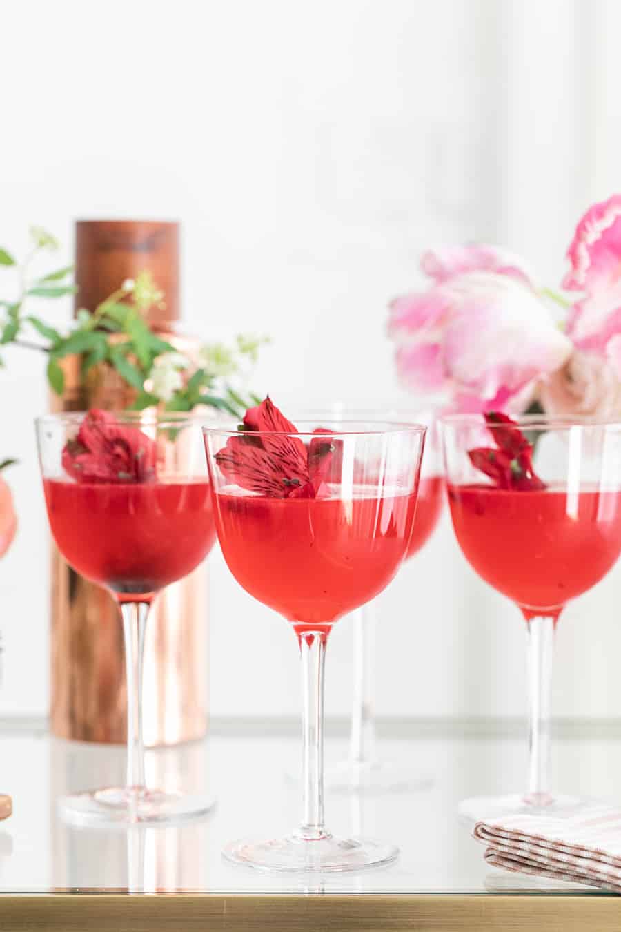 Beautiful pink cocktails garnished with flowers. 