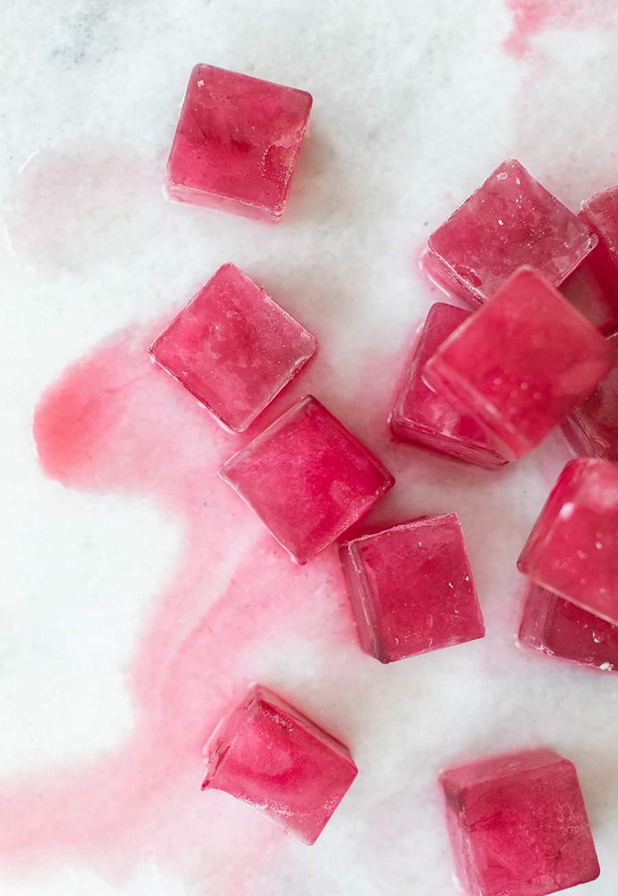 Pink ice cubes melting on a marbled table 