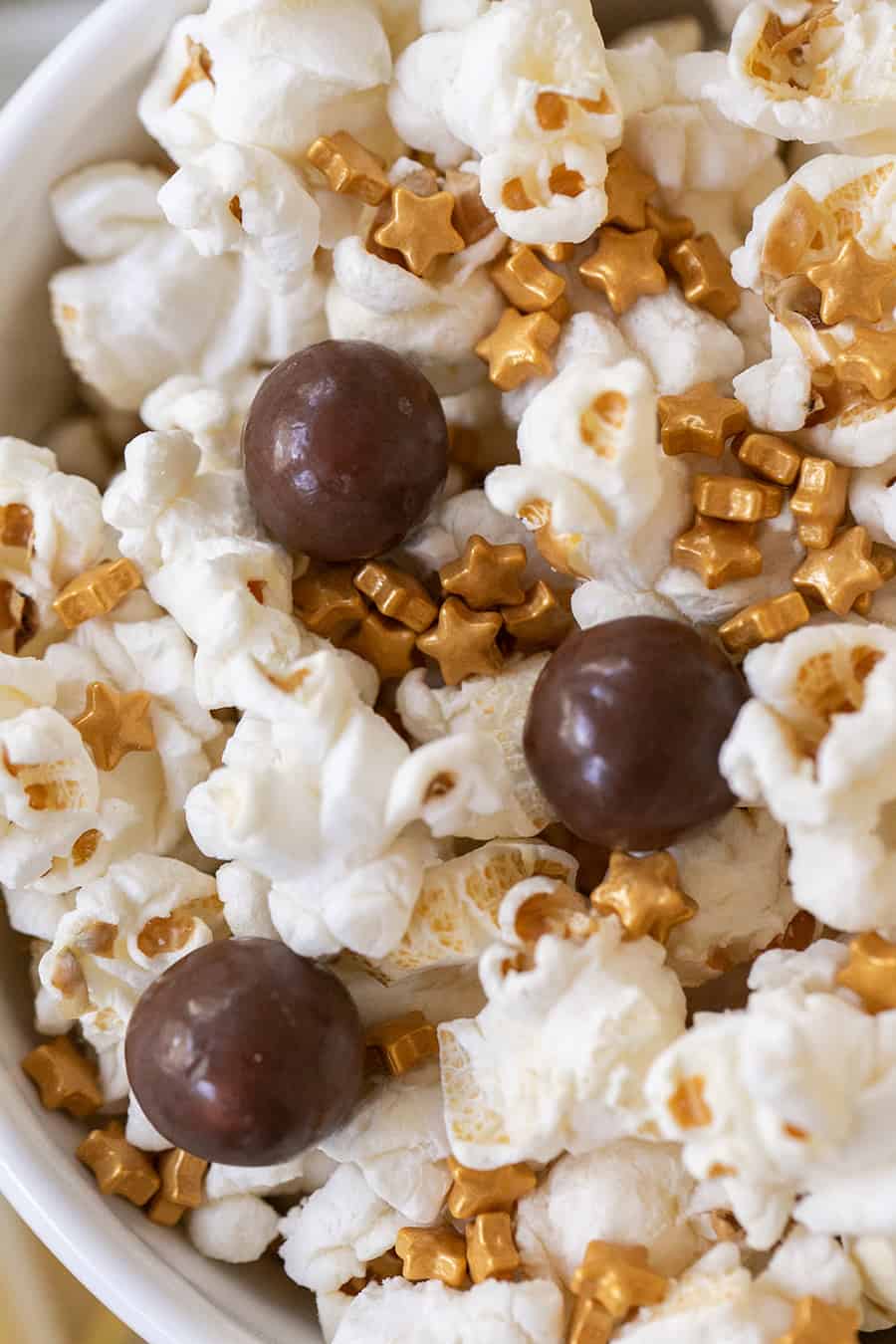 Popcorn with chocolate malt balls and gold sprinkles. 