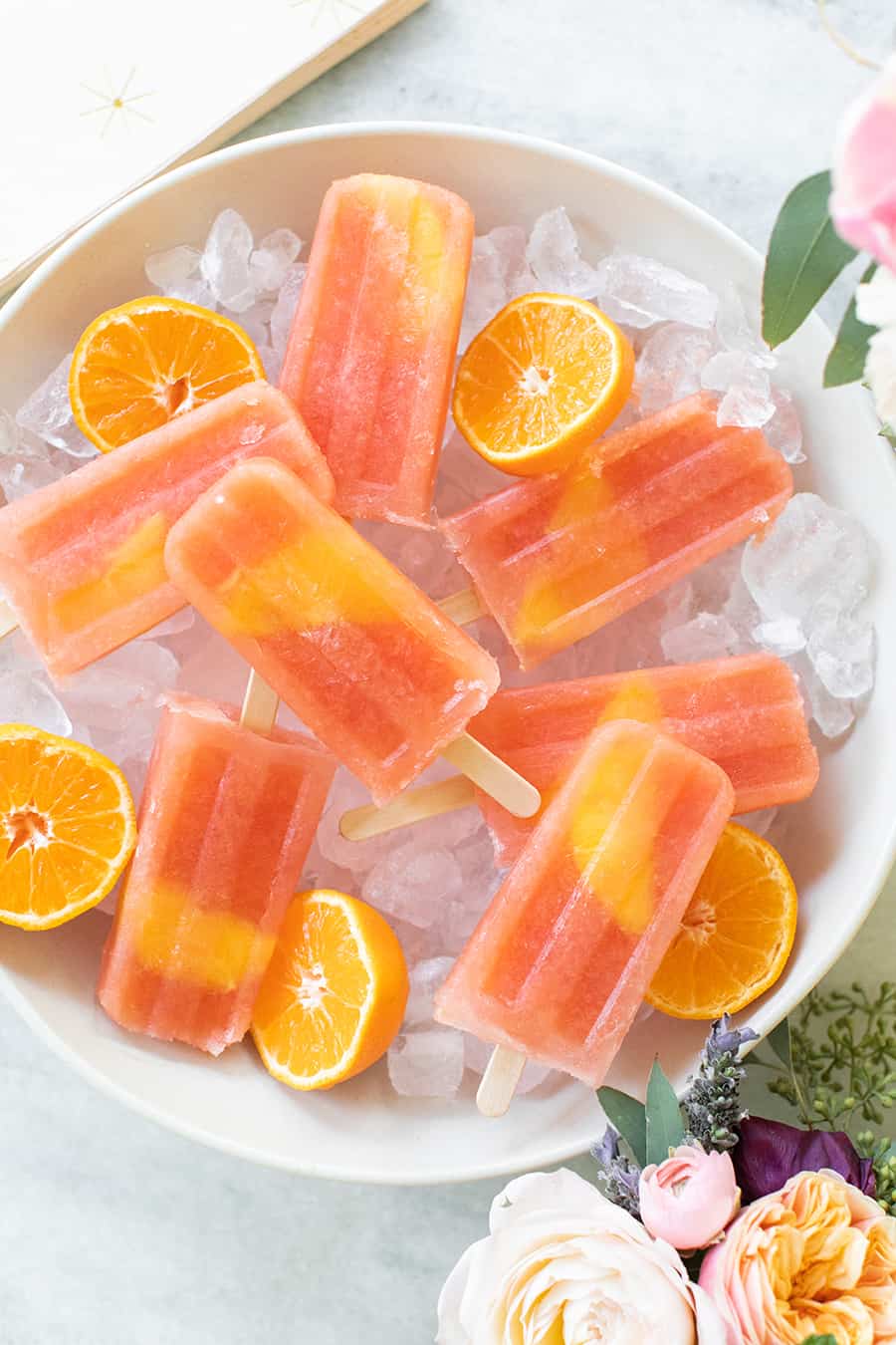 Negroni Popsicles over ice with orange slice