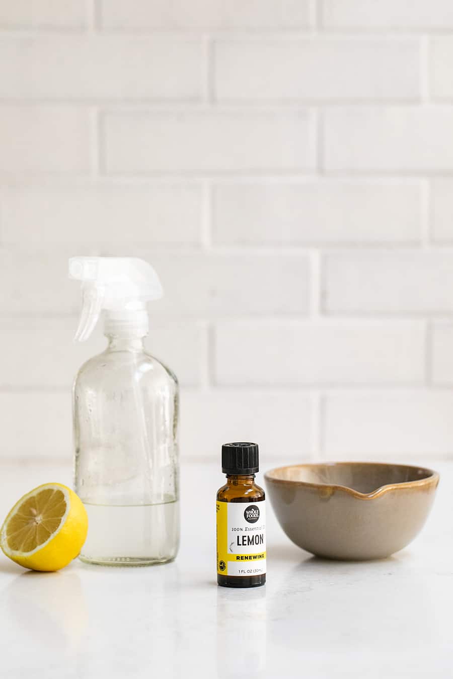 Lemon Oil, Lemon, Vinegar and a Clear Spray Bottle to make Natural Window Cleaner