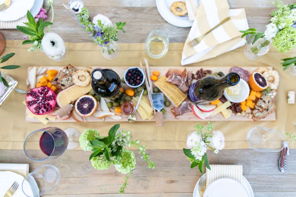 Overhead of cheese board and wine bottles. 